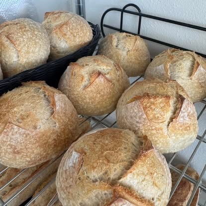 Overhead rack of golden country sourdough boules, fresh from the daily bake