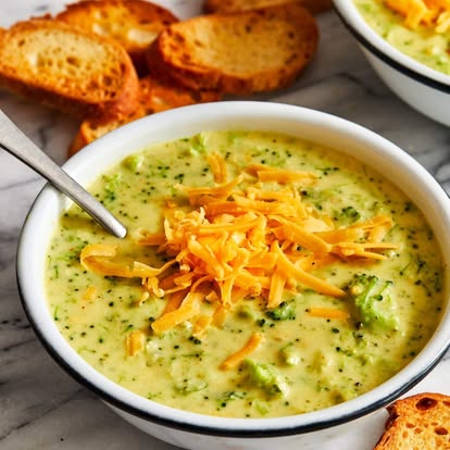 Broccoli cheddar soup in a white bowl with crostini